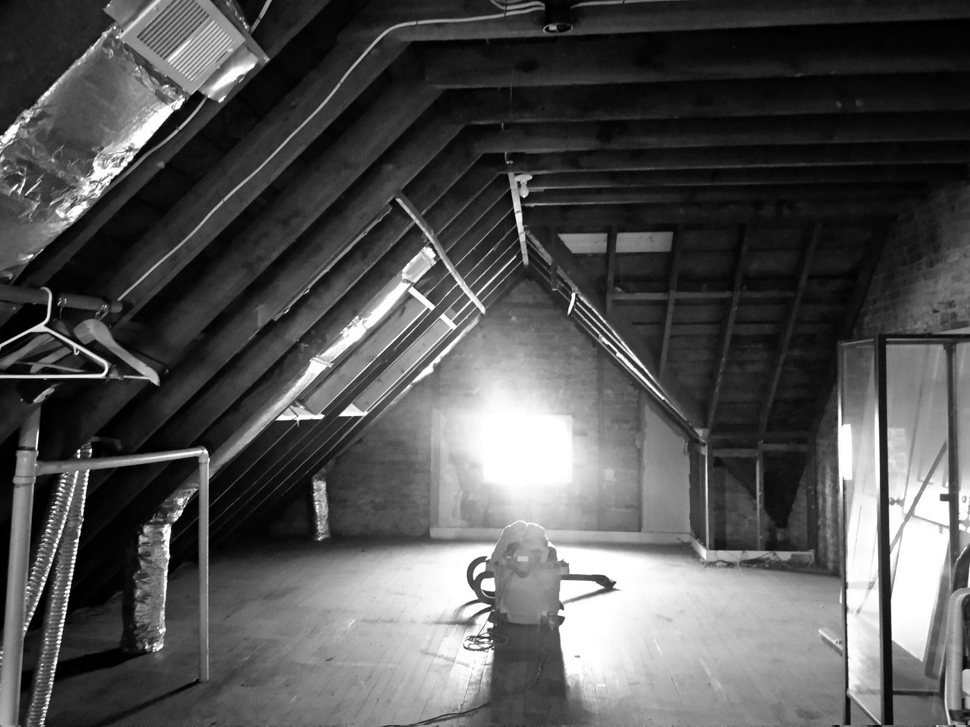 Unfinished attic with exposed rafters before renovation